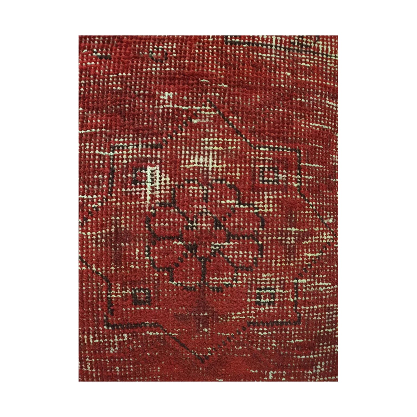 Close-up of dark floral medallion outlines across the red and ivory overdyed wool pile