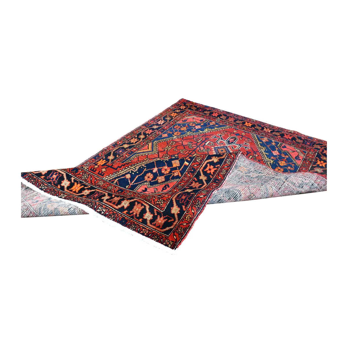 Folded view of vintage Persian Zanjan wool rug showing its central medallion, patterned pile and borders