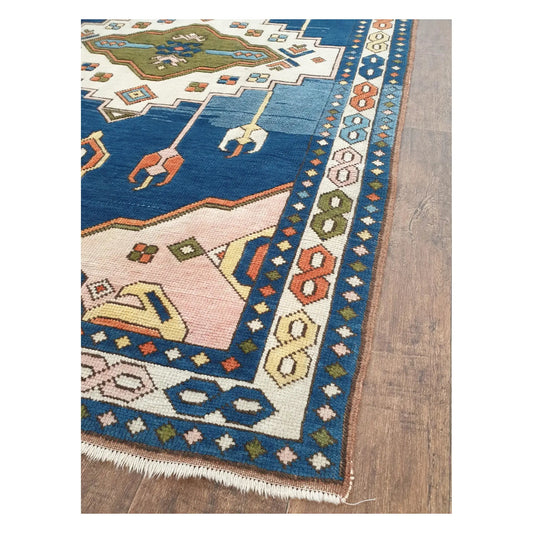 Border and fringe detail of a vintage Turkish Anatolian rug showing blue, ivory, olive, and coral geometric patterning