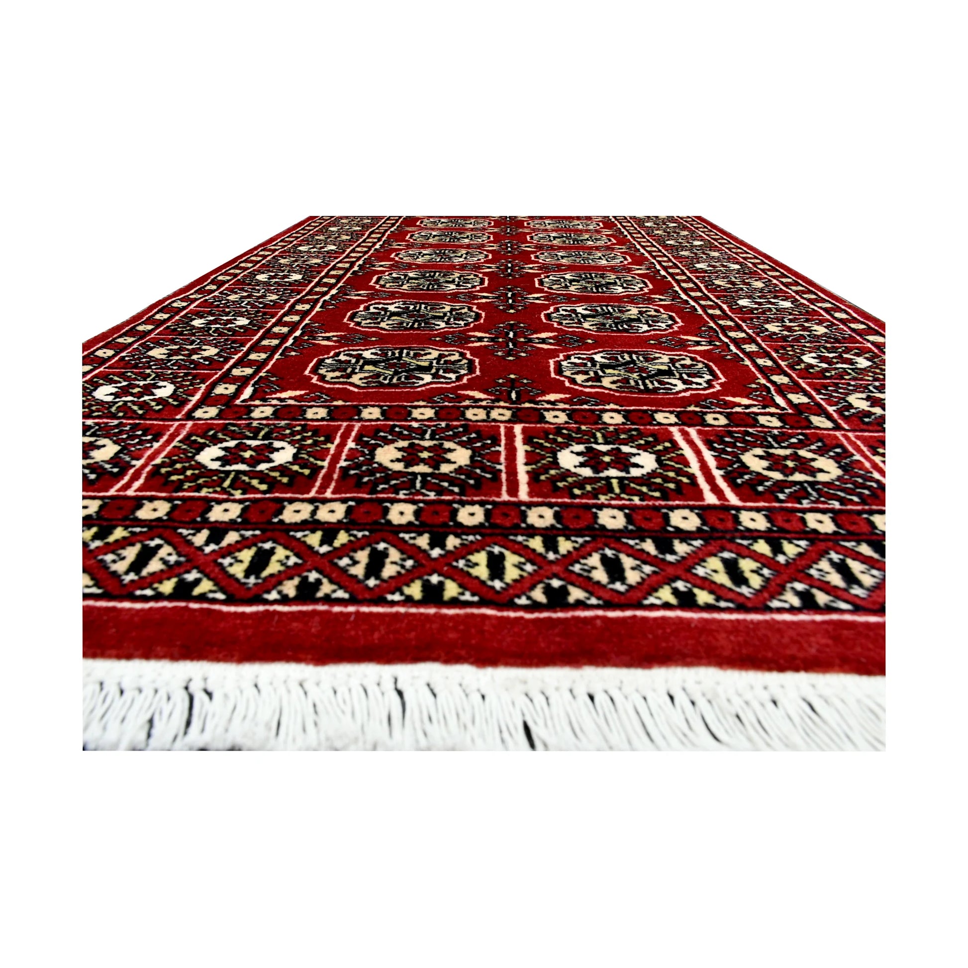 Fringe end detail of Afghan Bokhara runner rug showing repeated gul medallions, red field and geometric border