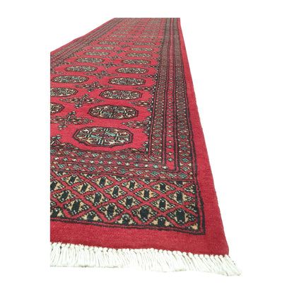 Angled border and fringe detail of Afghan Bokhara runner rug showing red wool pile and dark geometric edging