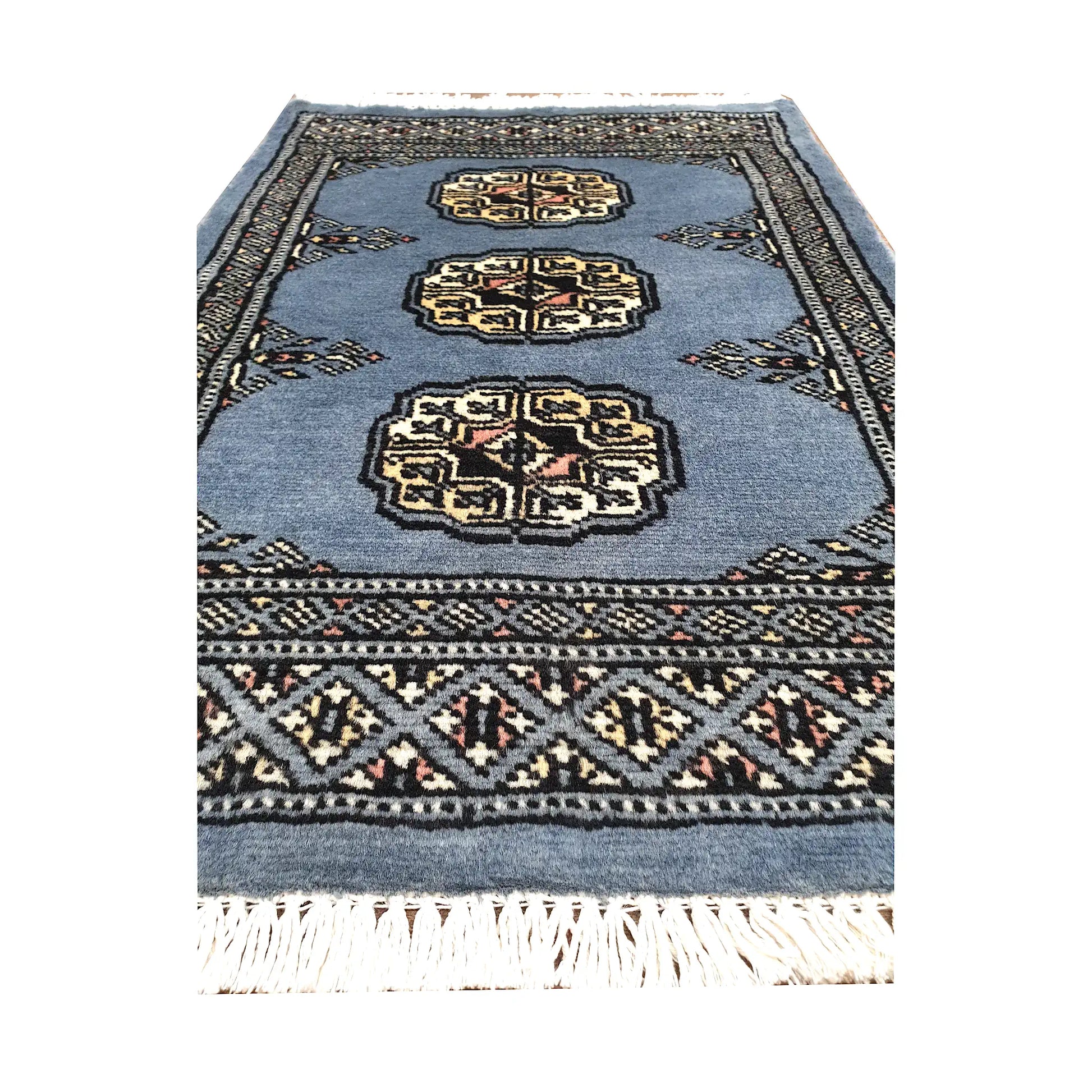 Blue-grey field and border detail of Afghan Bokhara wool rug showing three ivory gul medallions and geometric border