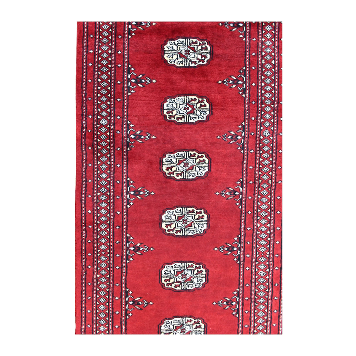Field detail of Bokhara runner showing a row of ivory guls between patterned borders on a red ground