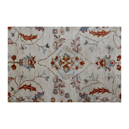 Close-up of beige Chobi rug showing the central floral motif, scrolling vines and pale blue accents