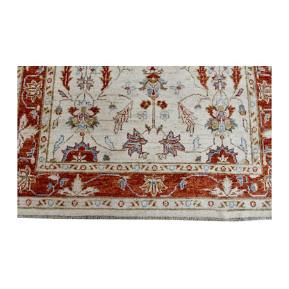 Fringe and end-border detail of Afghan Chobi rug with rust-red floral bands and pale blue accents