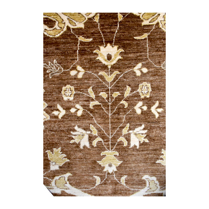 Field detail of Afghan Chobi rug showing a branching vine with ivory and blue-grey blossoms across warm brown