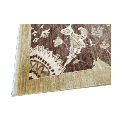Corner detail of Afghan Chobi brown floral rug showing border and wool pile texture