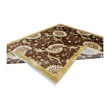Folded view of Afghan Chobi wool rug showing its brown floral field, ivory medallions and muted-gold border