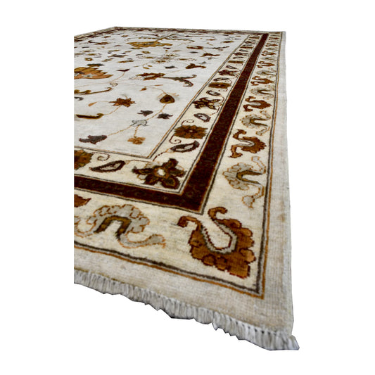 Angled view of Afghan Chobi rug showing its ivory botanical field, brown vine borders and white fringe