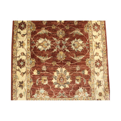 Lower field and side-border detail showing ivory floral motifs across the deep rust-red Chobi wool rug