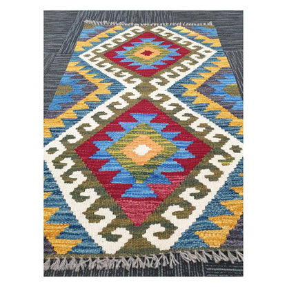 Angled view of Afghan Chobi Kilim flatweave rug showing elongated twin diamond motif, 100 x 61 cm