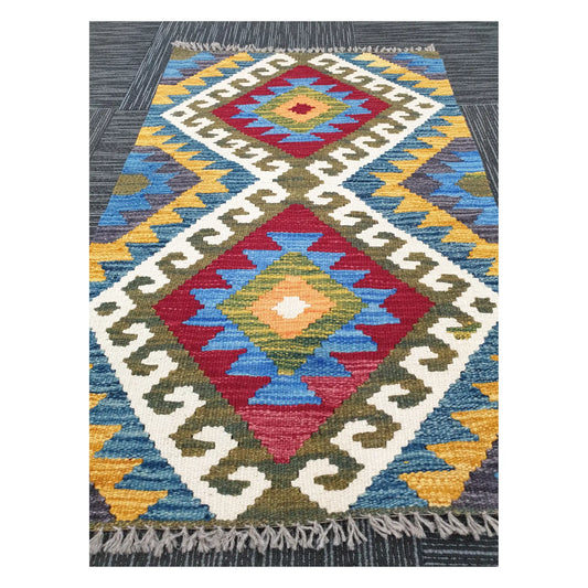 Angled view of Afghan Chobi Kilim flatweave rug showing elongated twin diamond motif, 100 x 61 cm