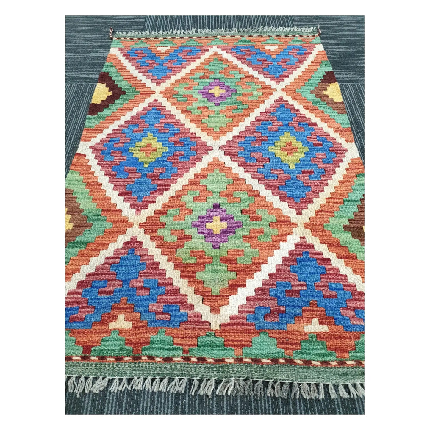 Angled view of Afghan Chobi Kilim flatweave rug showing geometric diamond trellis pattern, 100 x 65 cm
