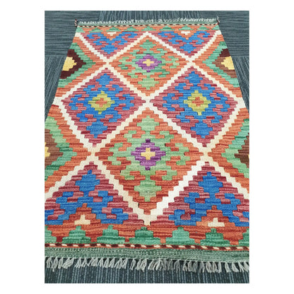 Angled view of Afghan Chobi Kilim flatweave rug showing geometric diamond trellis pattern, 100 x 65 cm