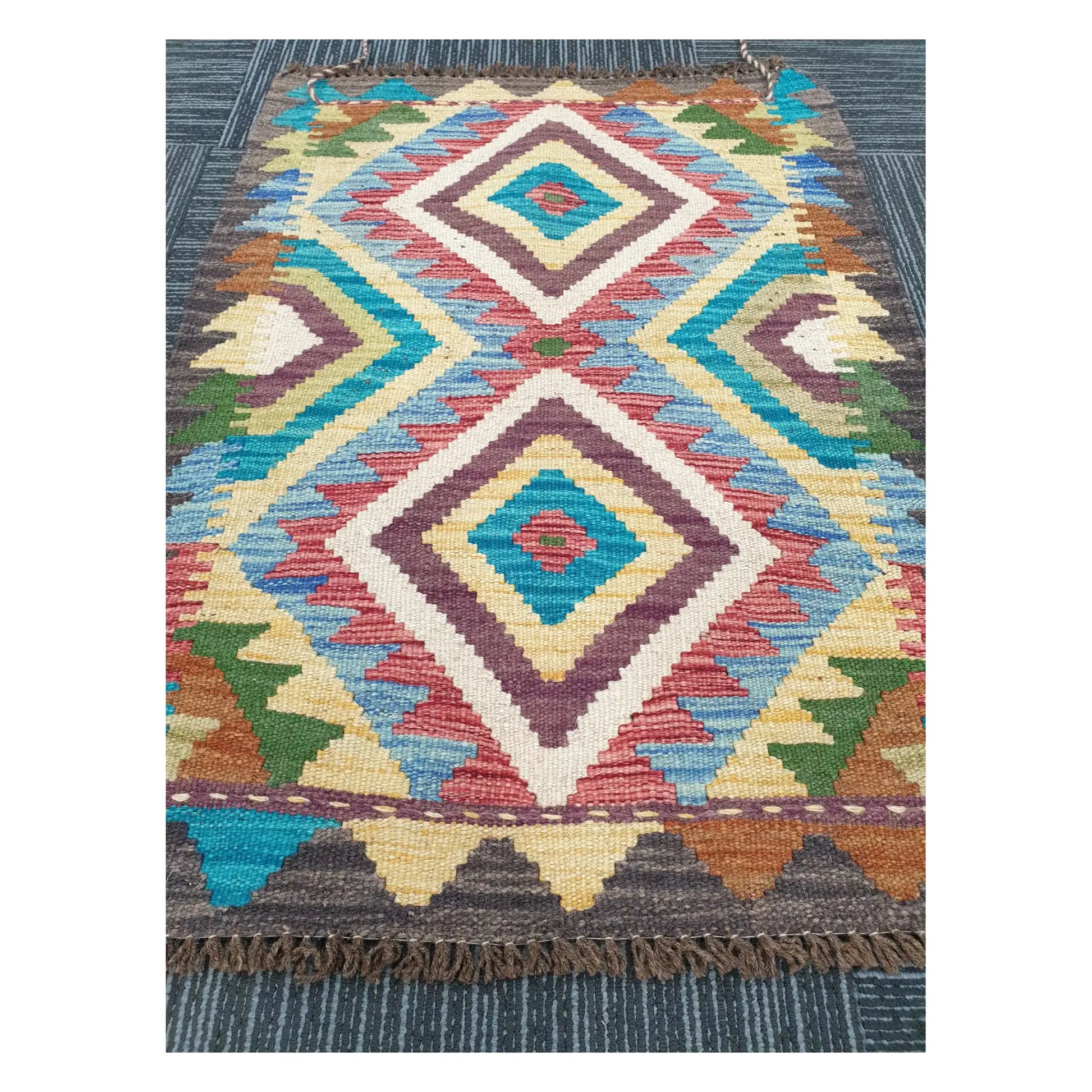 Angled view of Afghan Chobi Kilim flatweave rug showing elongated twin diamond motif, 84 x 60 cm