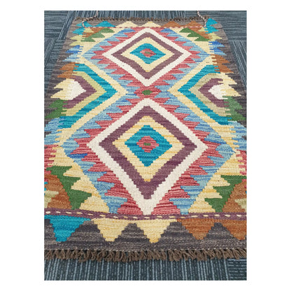 Angled view of Afghan Chobi Kilim flatweave rug showing elongated twin diamond motif, 84 x 60 cm
