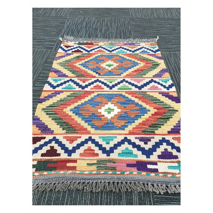 Angled view of Afghan Chobi Kilim flatweave rug showing geometric double diamond pattern, 85 x 60 cm
