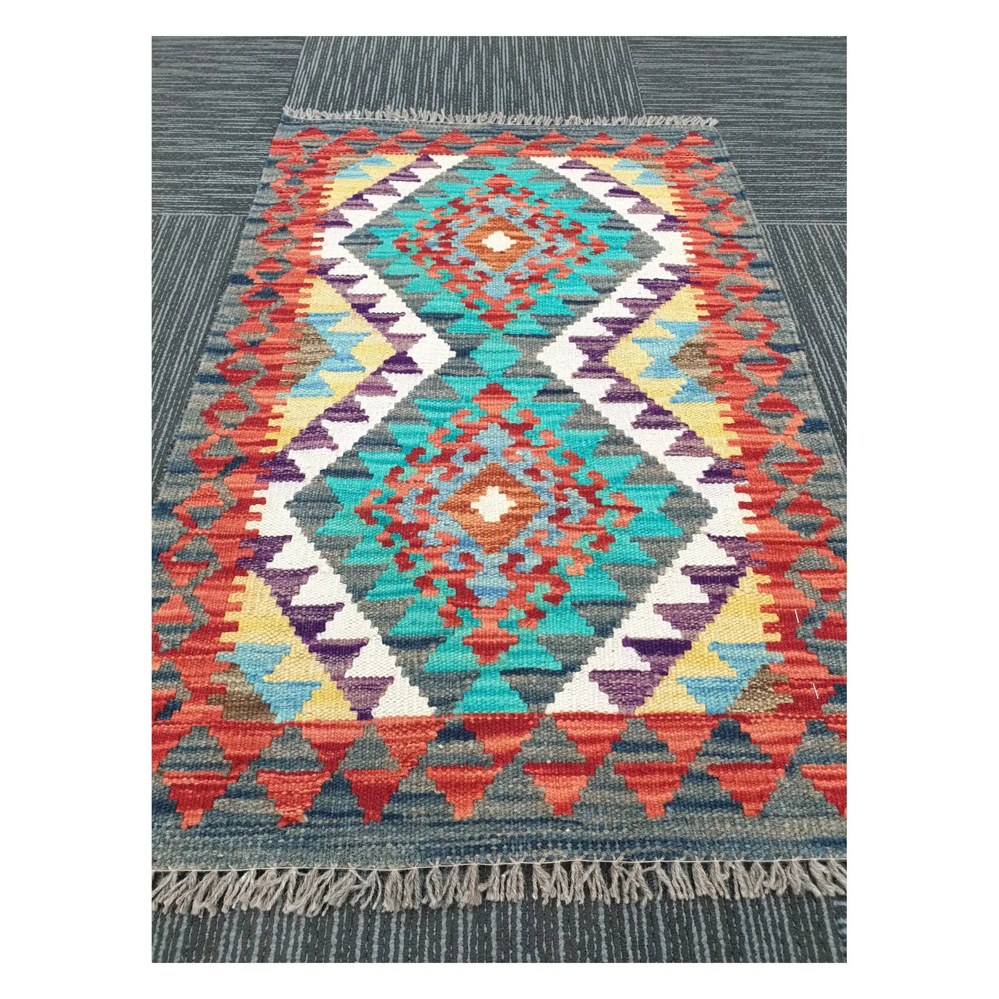 Angled view of Afghan Chobi Kilim flatweave rug showing geometric band pattern and centre diamond, 90 x 58 cm
