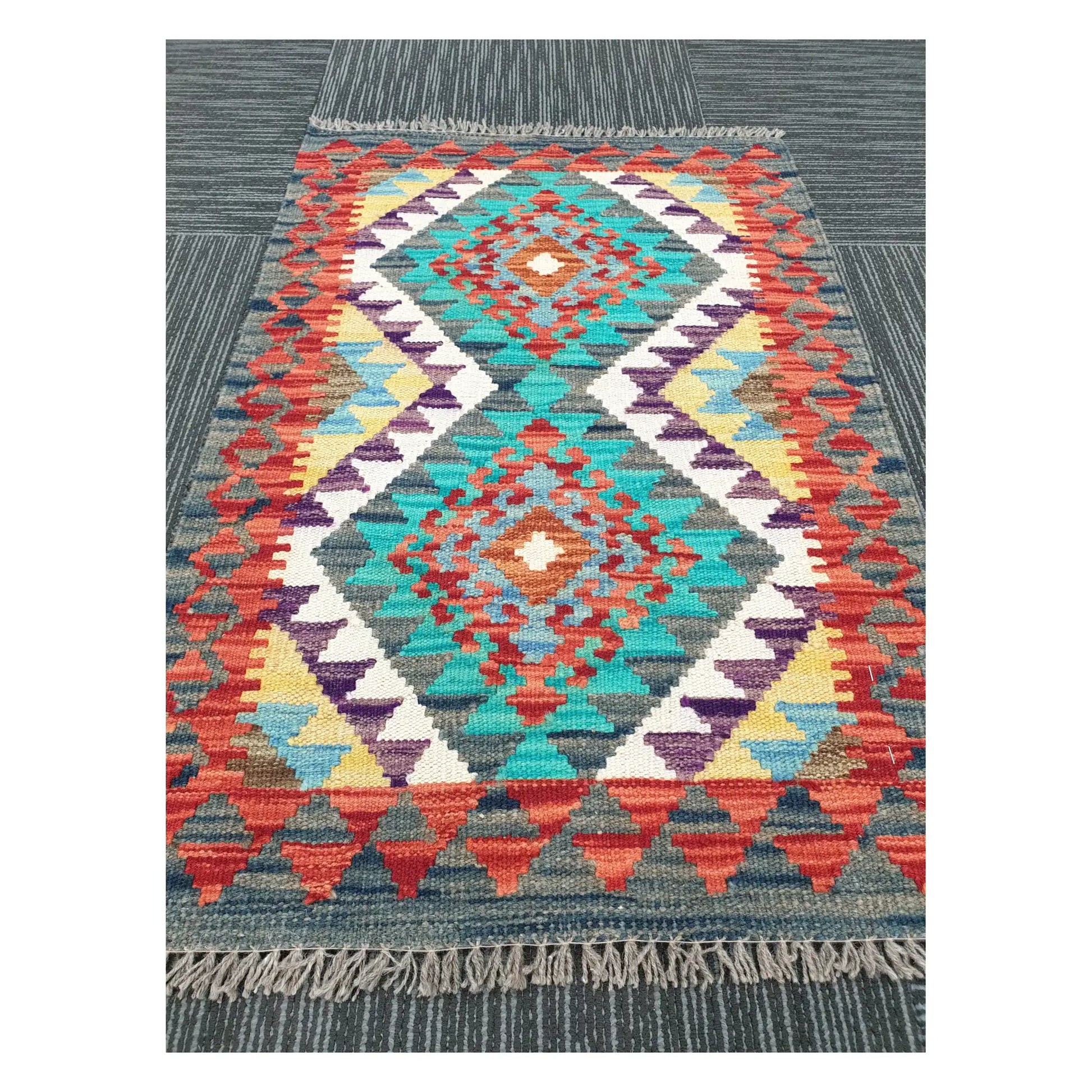 Angled view of Afghan Chobi Kilim flatweave rug showing geometric band pattern and centre diamond, 90 x 58 cm