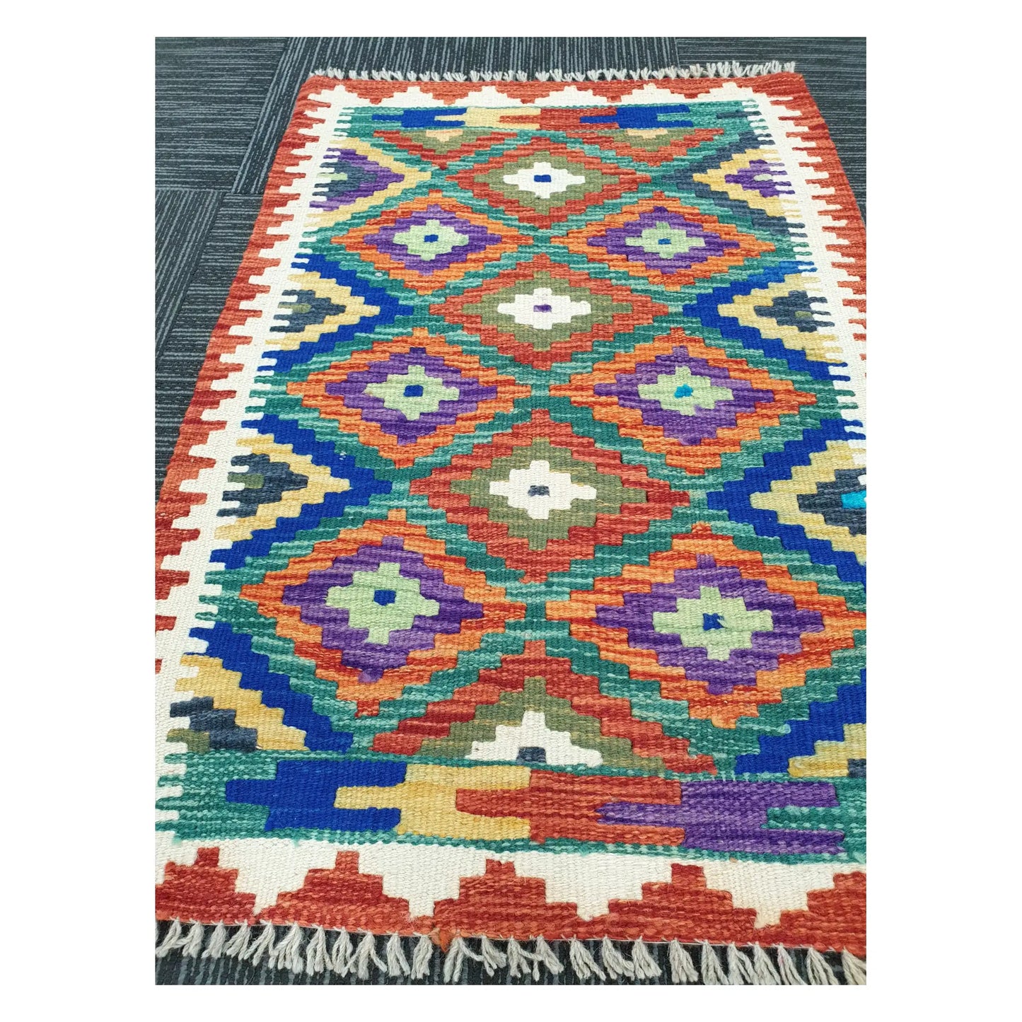 Angled view of Afghan Chobi Kilim flatweave rug showing multicolour diamond grid pattern, 90 x 60 cm