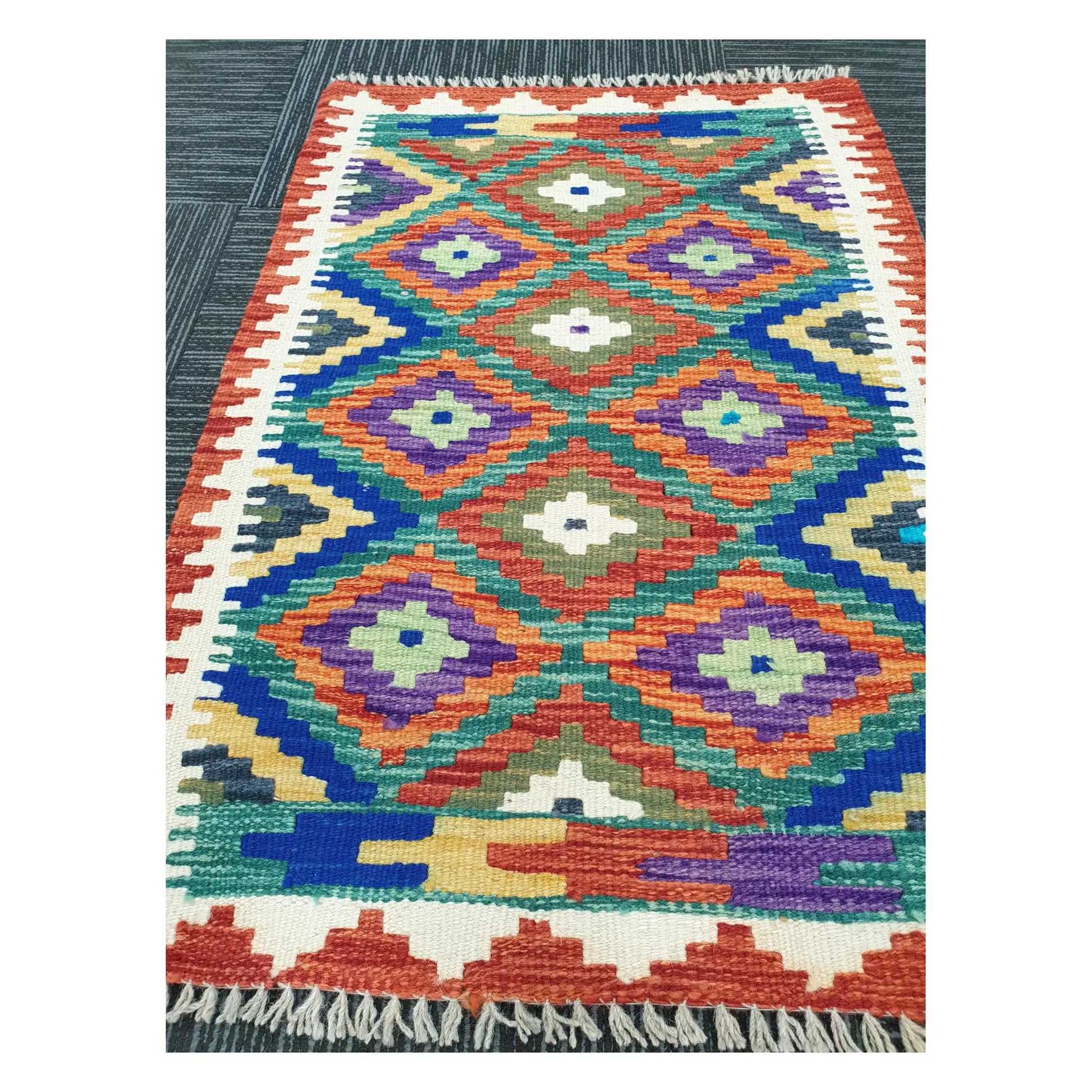 Angled view of Afghan Chobi Kilim flatweave rug showing multicolour diamond grid pattern, 90 x 60 cm