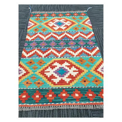 Angled view of Afghan Chobi Kilim flatweave rug showing geometric banded diamond pattern, 90 x 61 cm
