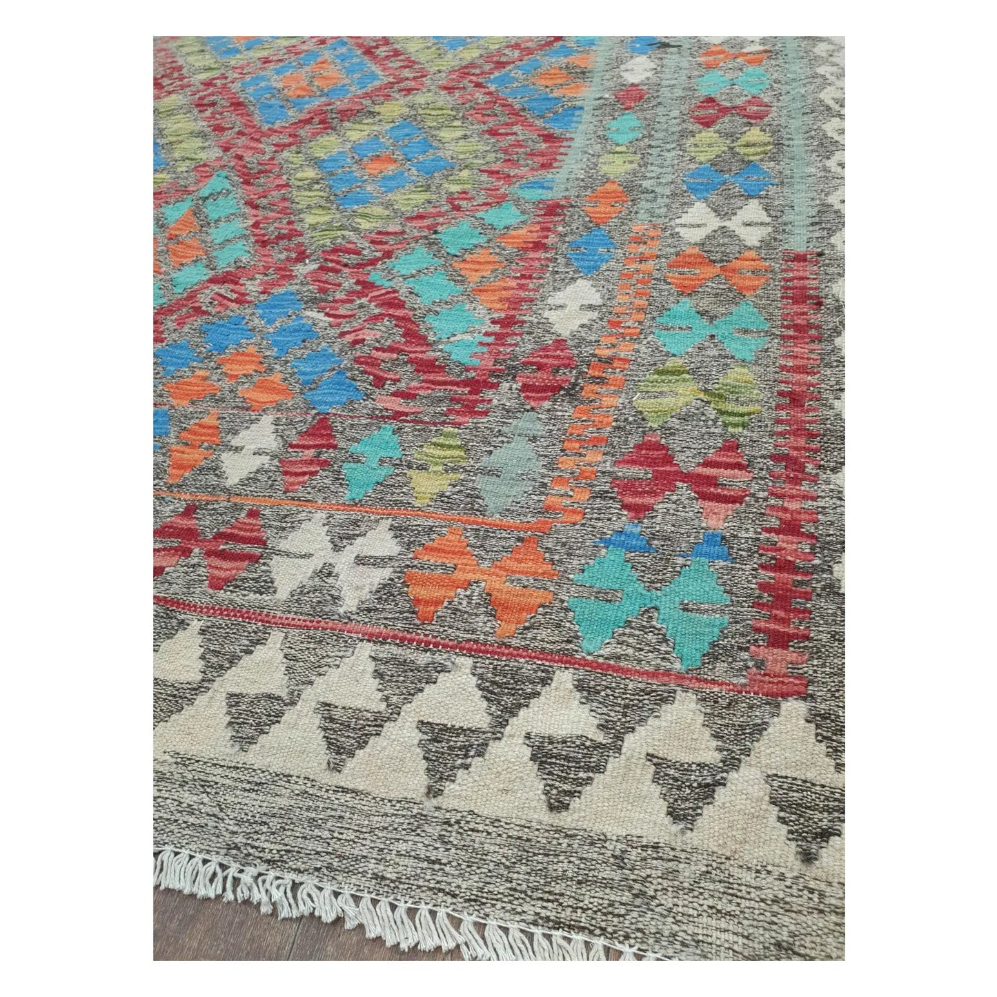 Border detail of Afghan Chobi Kilim blue medallion rug showing rust orange and ivory motifs