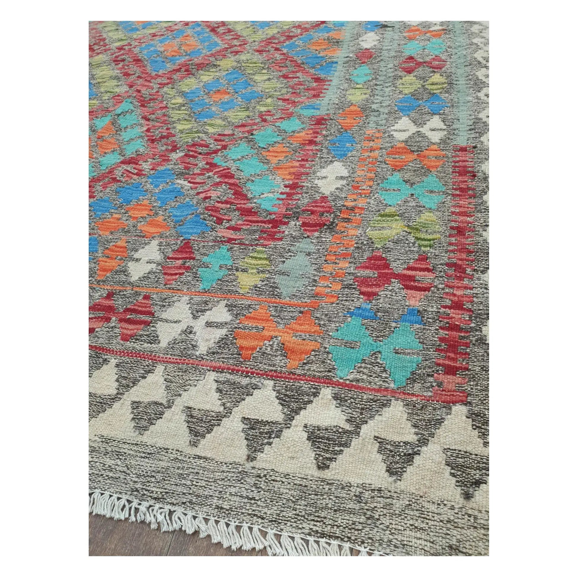Border detail of Afghan Chobi Kilim blue medallion rug showing rust orange and ivory motifs