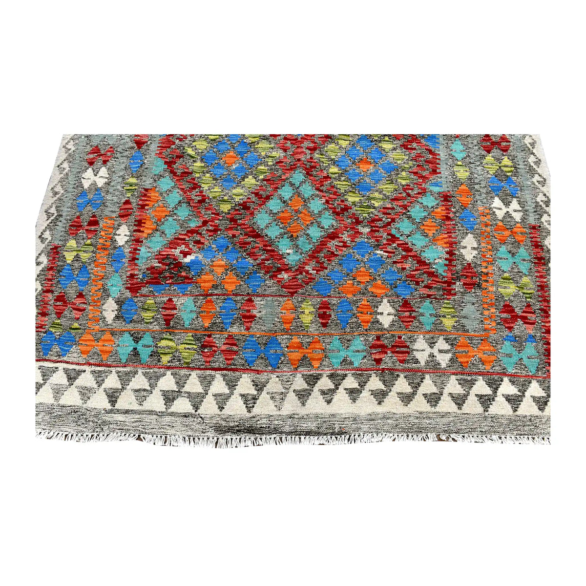 Fringe-end detail of Afghan Chobi Kilim rug showing blue and turquoise diamonds above layered geometric borders and an ivory triangle band.