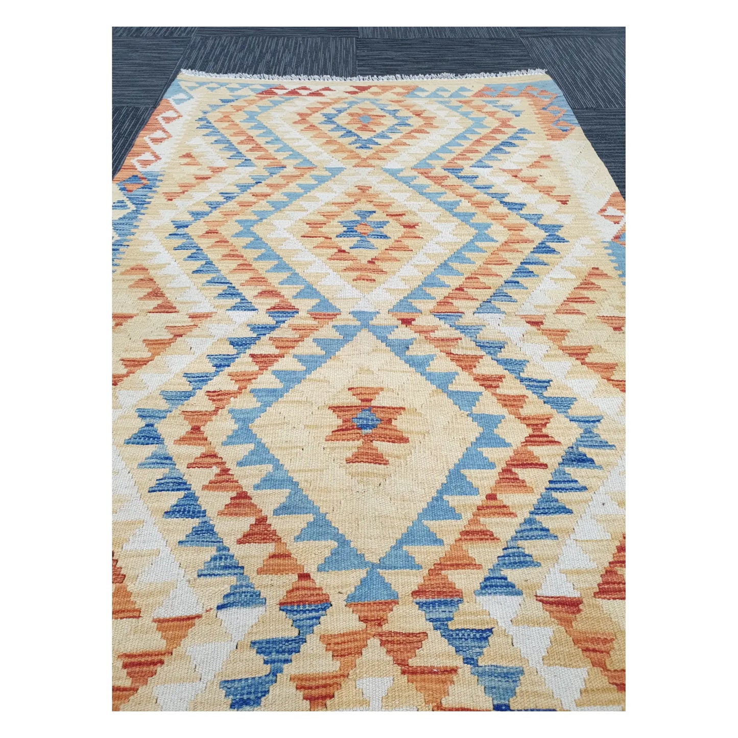 Close-up of Chobi Kilim rug with stepped diamond motifs in powder blue, terracotta, sand, and muted gold, 188 x 103 cm
