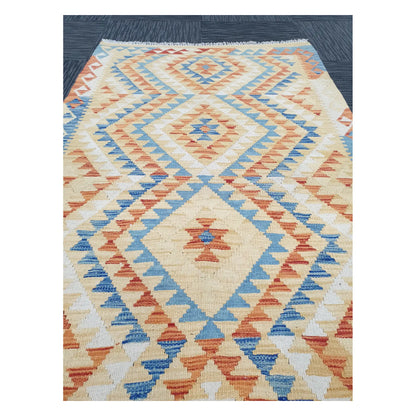 Close-up of Chobi Kilim rug with stepped diamond motifs in powder blue, terracotta, sand, and muted gold, 188 x 103 cm