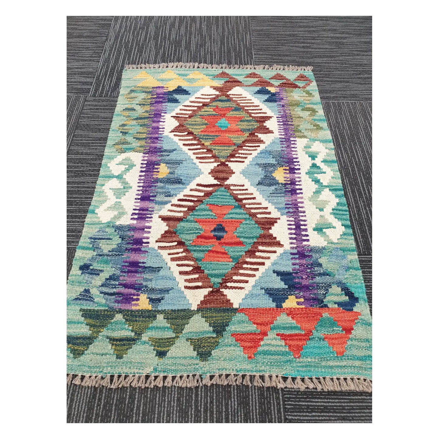 Angled view of Afghan Chobi Kilim rug showing twin-diamond motif and fringe, 88 x 59 cm