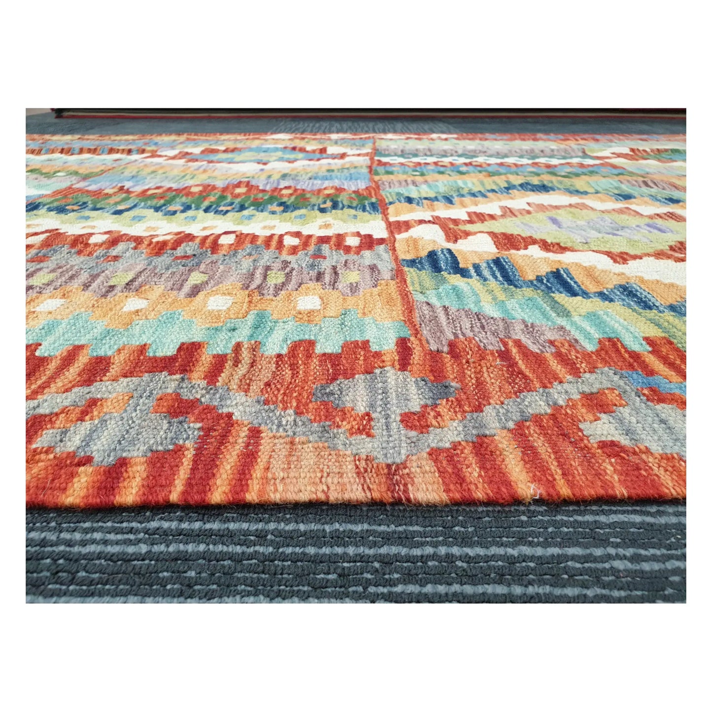 Low-angle close-up of Afghan Chobi Kilim showing hand-woven wool texture and striped geometric pattern, 180 x 122 cm