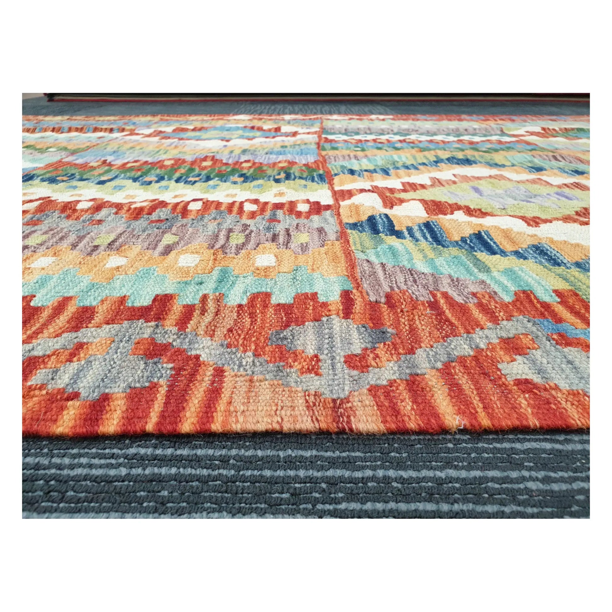 Low-angle close-up of Afghan Chobi Kilim showing hand-woven wool texture and striped geometric pattern, 180 x 122 cm