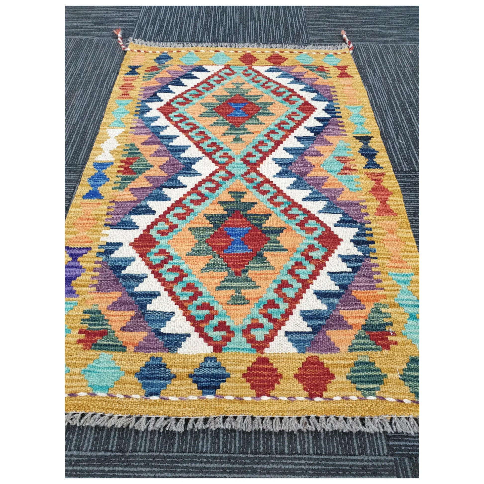 Angled view of small Afghan Chobi Kilim wool rug showing geometric flatweave design, 92 x 60 cm