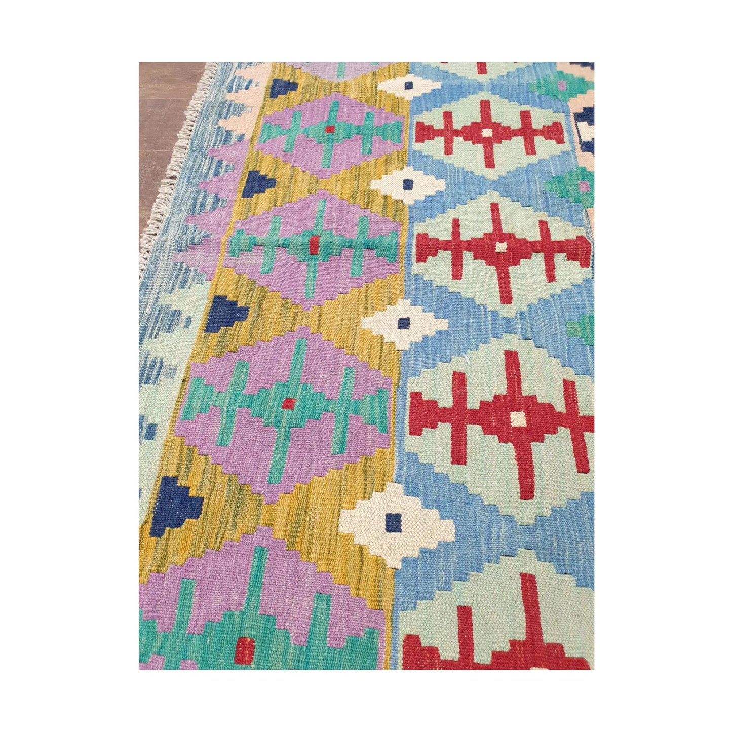 Side detail of Afghan Chobi Kilim pastel tribal rug showing aqua, red and ivory motifs