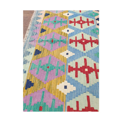 Side detail of Afghan Chobi Kilim pastel tribal rug showing aqua, red and ivory motifs