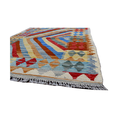 Angled edge detail of Afghan Chobi Kilim rug showing fringe, flatwoven wool texture and bold chevron pattern