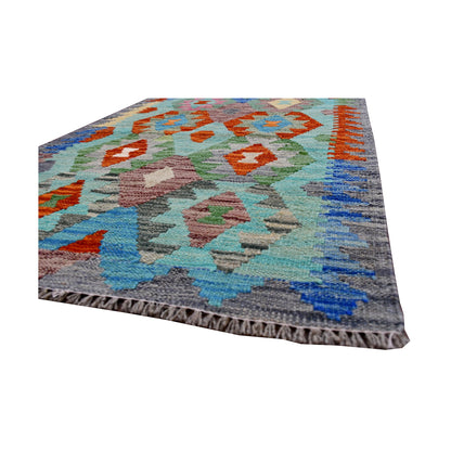 Angled fringe and edge detail of Afghan Chobi Kilim rug showing flatwoven wool texture and bright geometric motifs