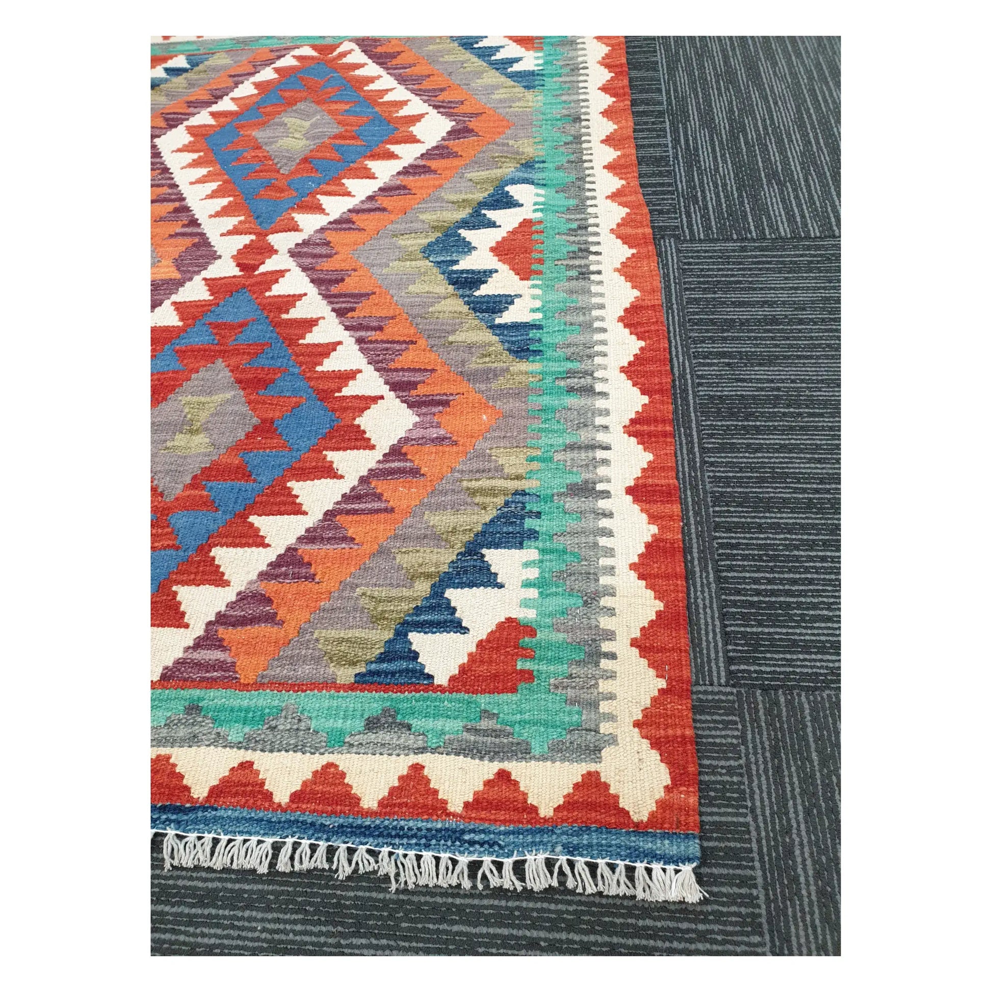 Angled detail of Afghan Chobi Kilim showing fringe, stepped border pattern, and flatweave texture, 119 x 84 cm