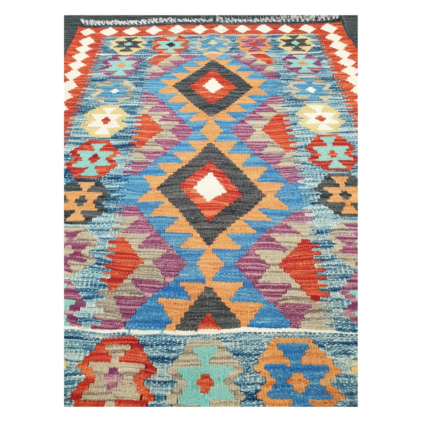 Close-up of Chobi Kilim rug with stacked diamond medallions in sky blue, rust red, ivory, and lilac, 123 x 90 cm