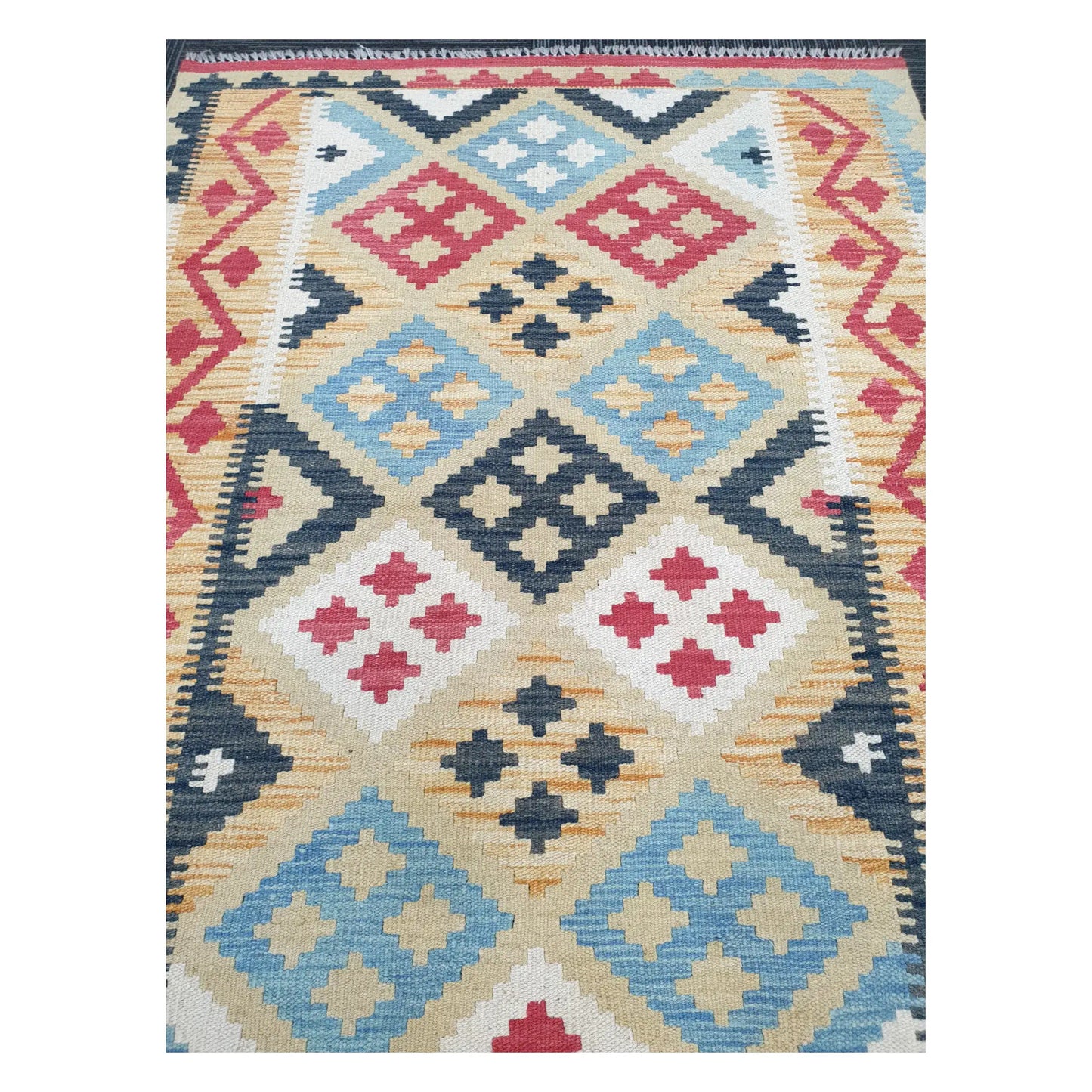 Close-up of Chobi Kilim rug with blue, charcoal, and ivory diamond motifs with tribal accents, 144 x 100 cm