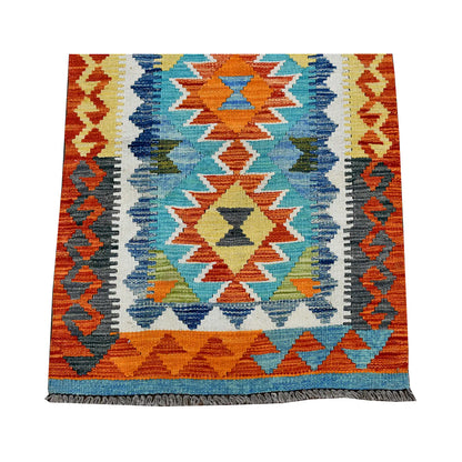End section detail of Afghan Chobi Kilim runner with orange border and geometric medallion on turquoise-blue field