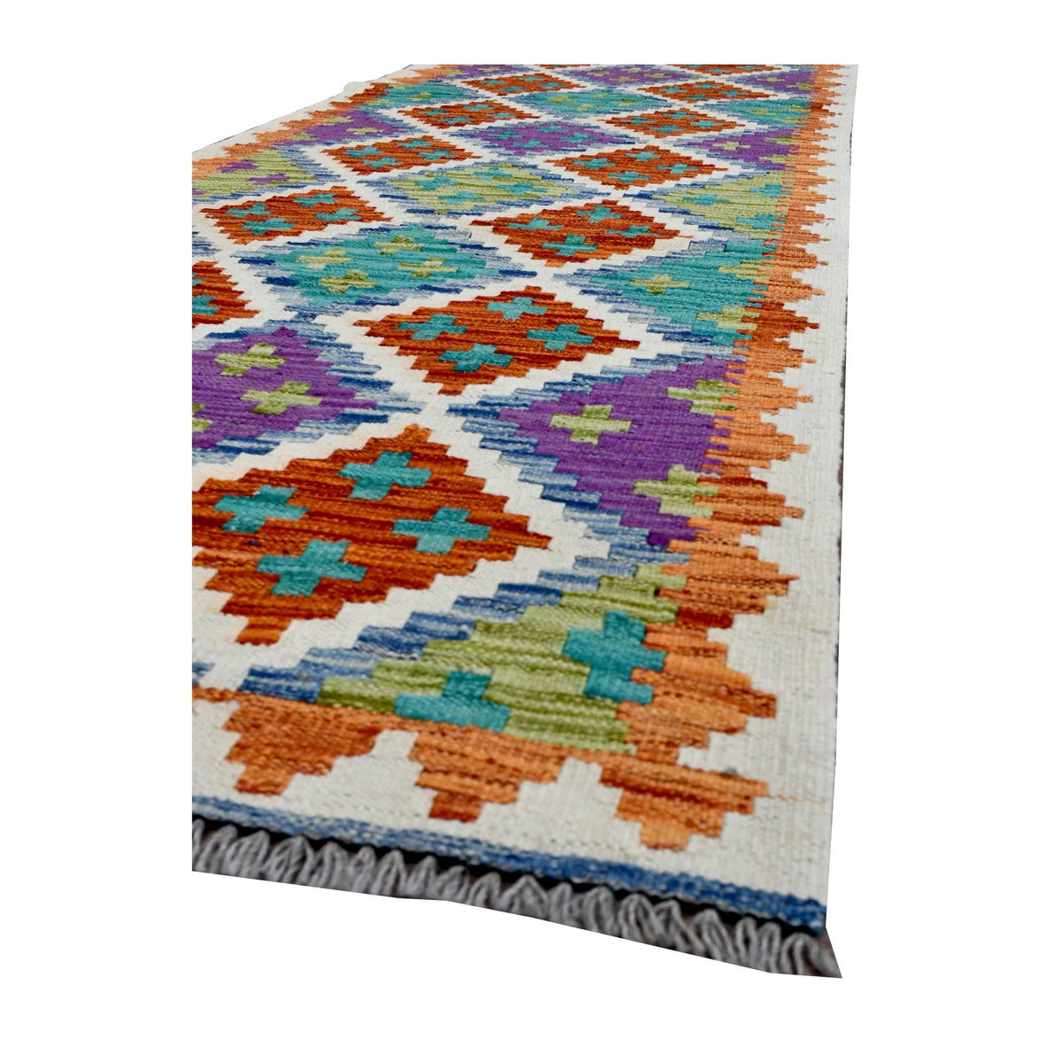 Angled corner of Afghan Chobi Kilim runner showing stepped diamond motifs, zigzag edging and grey fringe