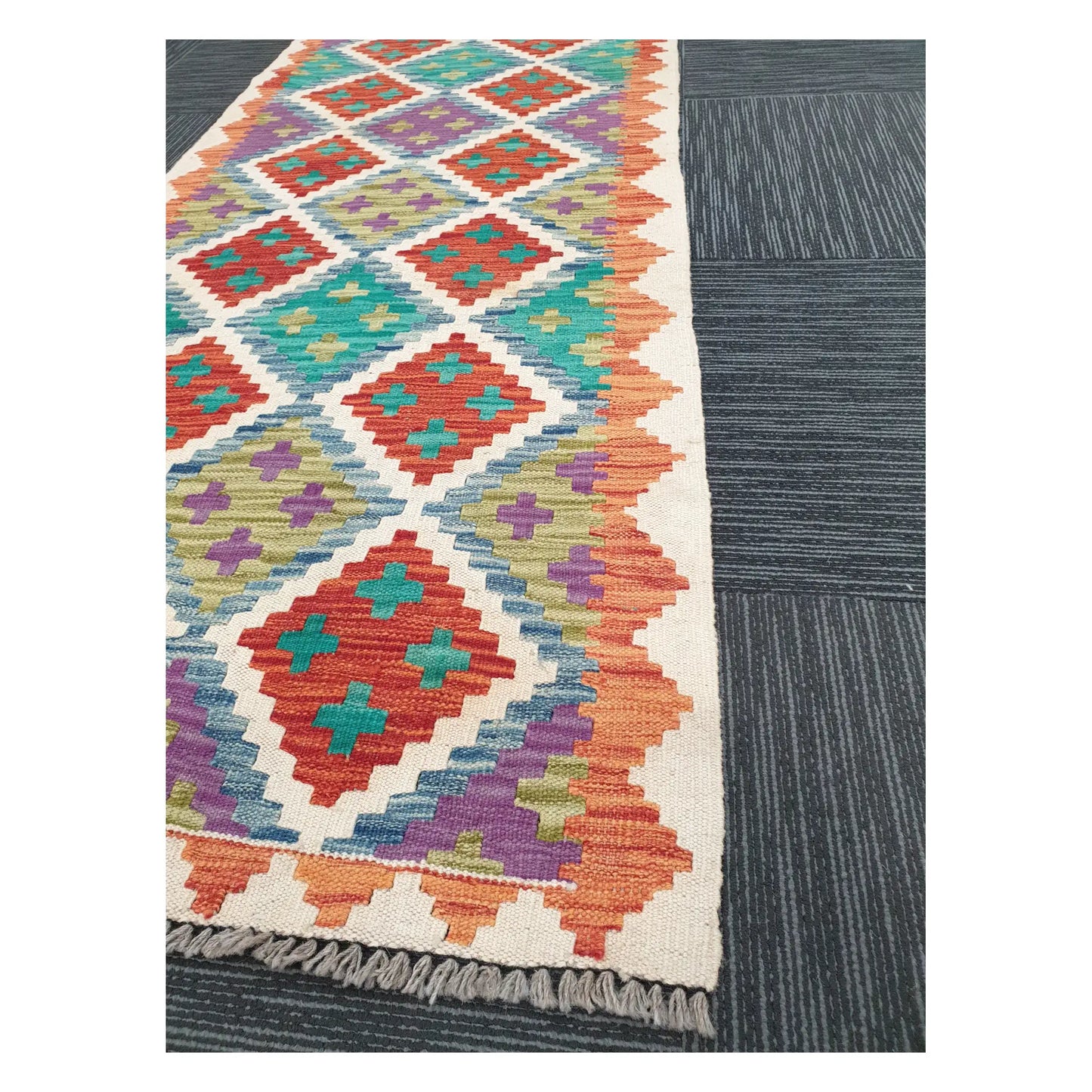 Angled view of Afghan Chobi Kilim runner showing multicolour diamond trellis pattern and fringe, 286 x 77 cm