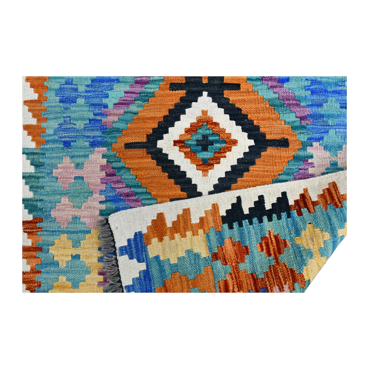 Folded fringe end of Afghan Chobi Kilim runner showing the patterned face, reverse weave and grey fringe