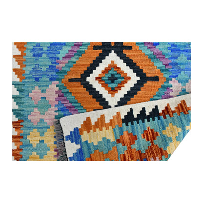 Folded fringe end of Afghan Chobi Kilim runner showing the patterned face, reverse weave and grey fringe