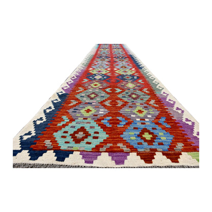 Angled full view of Afghan Chobi Kilim runner showing its elongated coral-red field, linked medallions and stepped side borders