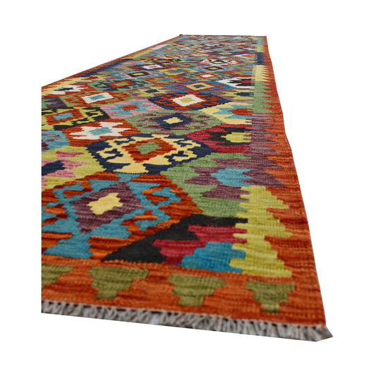 Angled edge and fringe detail of Afghan Chobi Kilim runner showing wool flatweave texture and bright geometric motifs