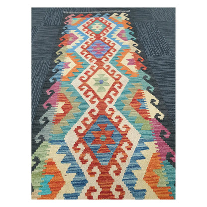 Angled view of Afghan Chobi Kilim runner rug showing elongated linked diamond motif, 194 x 63 cm